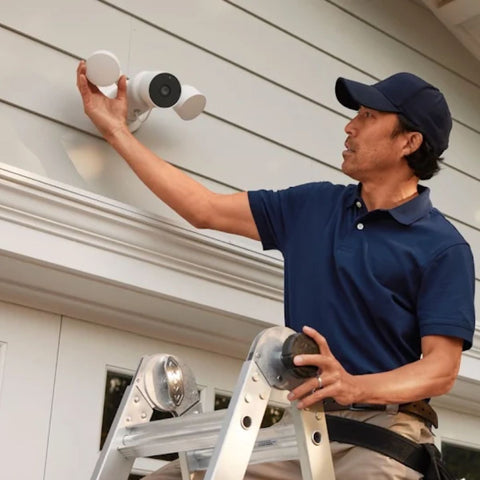 A professional installer helps install a Nest Cam with floodlight on someone's home.